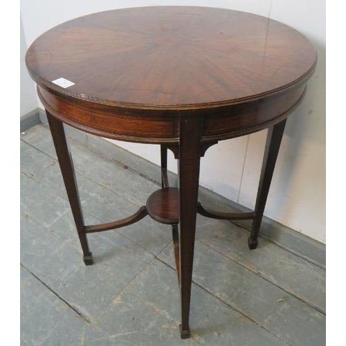 762 - An Edwardian mahogany occasional table strung with ebony, on tapering square supports united by a br... 