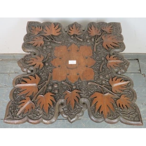 764 - An early 20th century Anglo Indian folding table, the shaped top with high relief carving depicting ... 