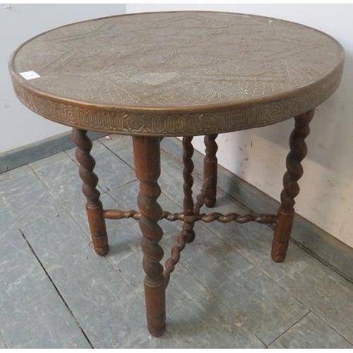 765 - An antique Benares table, the tooled brass tray top with central lion motif, on folding barley twist... 