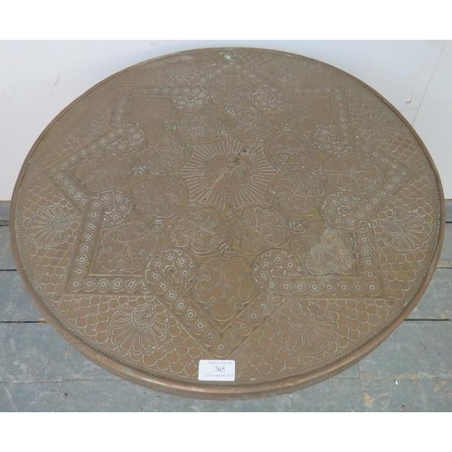 765 - An antique Benares table, the tooled brass tray top with central lion motif, on folding barley twist... 