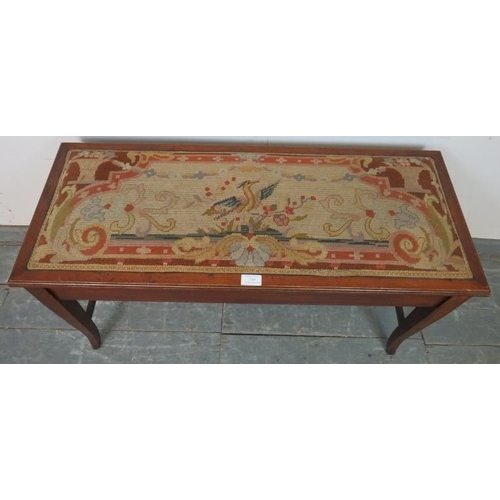 766 - An Edwardian mahogany duet stool, the tapestry seat opening onto two storage compartments, on taperi... 