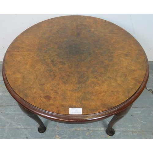 773 - An antique burr walnut circular coffee table, the quarter veneered top with central roundel, on cabr... 