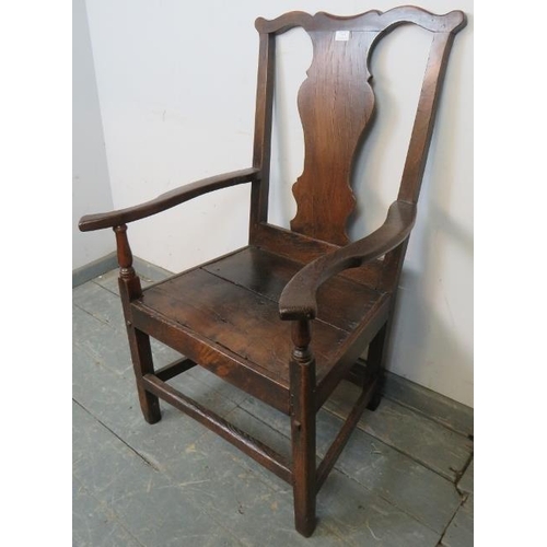 775 - An early 18th century oak elbow chair in the Queen Anne taste, with shaped back splat, on square sup... 