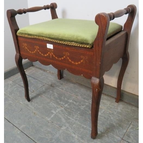 779 - An Edwardian mahogany piano stool, the green velvet seat opening onto a storage well, with marquetry... 