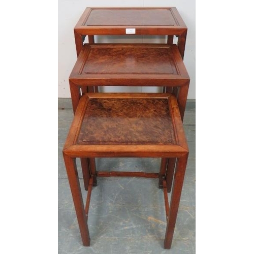 782 - A set of three Chinese walnut nesting tables, with fielded burr walnut inset tops and foliate carved... 