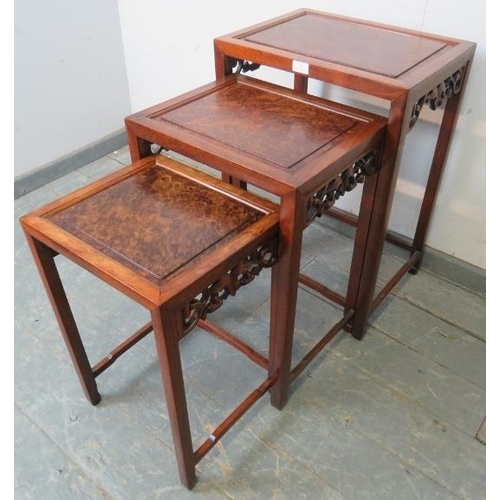 782 - A set of three Chinese walnut nesting tables, with fielded burr walnut inset tops and foliate carved... 