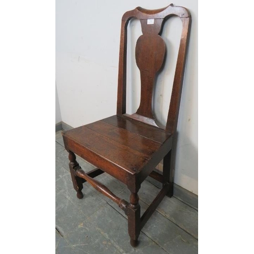 784 - An early 18th century oak hall chair, with shaped back splat, on turned and block supports with stre... 