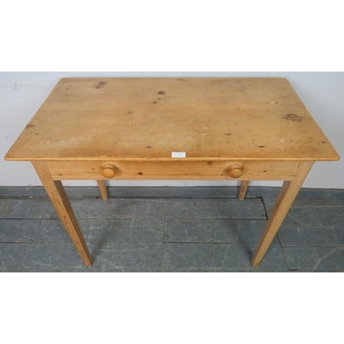 787 - An antique stripped pine side table housing one long drawer with turned wooden handles, on tapering ... 