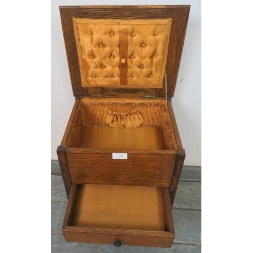 790 - An Art Deco Period oak sewing table, the hinged lid opening onto a gold silk lined interior, above a... 