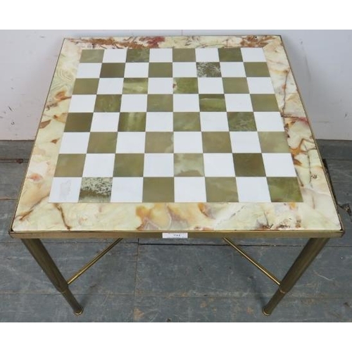 794 - A vintage games table with onyx and marble chessboard top, on tapering gilt brass supports united by... 