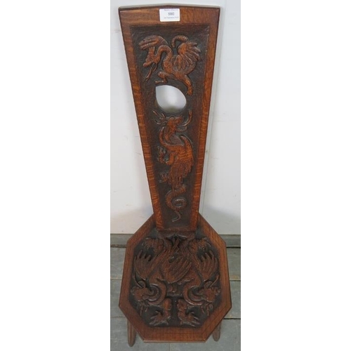 800 - A vintage oak spinning stool with high relief carving to backrest and seat depicting dragons, on ree... 