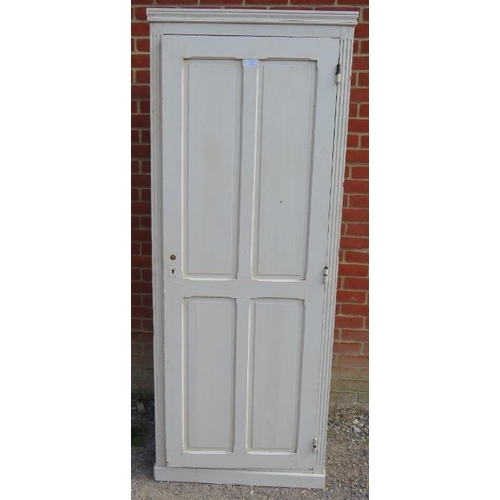 803 - An antique pitch pine tall pantry cupboard painted white, the panelled door opening onto three loose... 