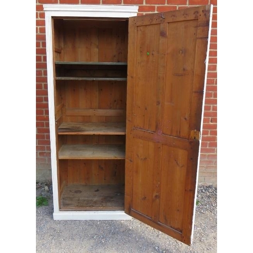 803 - An antique pitch pine tall pantry cupboard painted white, the panelled door opening onto three loose... 