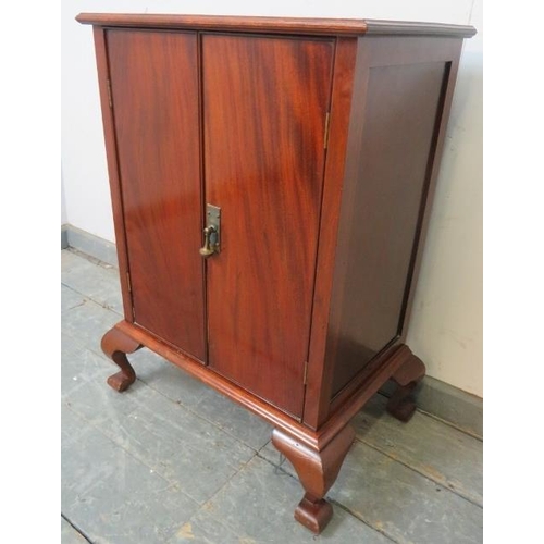 819 - An antique flame mahogany side cabinet, the twin cock-beaded doors opening onto two fitted shelves, ... 