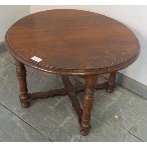 821 - An antique oak low circular side table, on tapering supports with a shaped ‘X’ stretcher. 
H42cm Dia... 