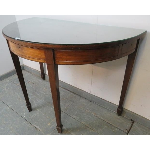 828 - A Georgian mahogany demi-lune serving table strung with ebony, housing three blind drawers, on taper... 