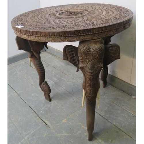 839 - A well-carved vintage Anglo Indian elephant table, the top carved in high relief with central panel ... 