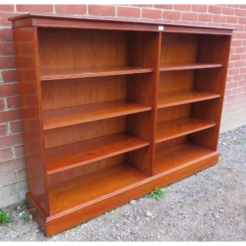 840 - A large yew wood low open bookcase, housing six height adjustable shelves with reeded edges, on a pl... 