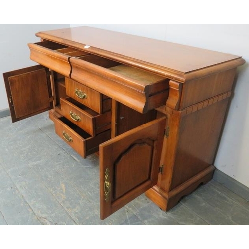 851 - A vintage antique-style walnut sideboard, housing two blind drawers above three short drawers and tw... 