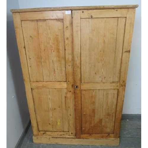 852 - An antique stripped pine narrow pantry cupboard, the panelled doors opening onto three loose shelves... 