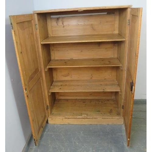 852 - An antique stripped pine narrow pantry cupboard, the panelled doors opening onto three loose shelves... 