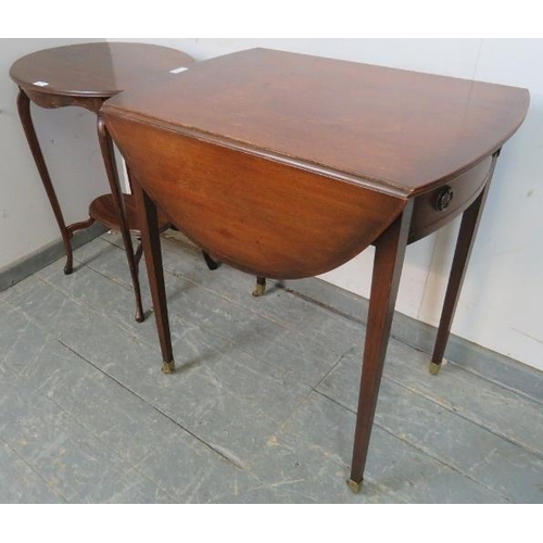 853 - A vintage mahogany drop leaf oval table in the Regency taste, housing single drawer with brass drop-... 