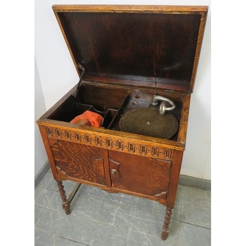 861 - A 1920s oak cased floor-standing gramophone by Atlas, on barley twist supports with an ‘H’ stretcher... 