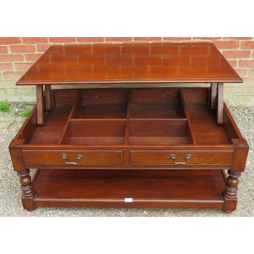 863 - A heavy oak coffee table in the 18th century taste, the top rising to reveal a storage well, having ... 