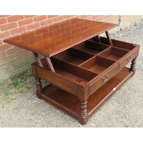 863 - A heavy oak coffee table in the 18th century taste, the top rising to reveal a storage well, having ... 