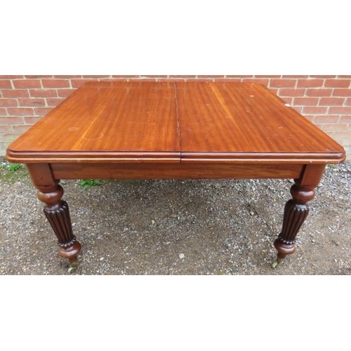 880 - A large Victorian mahogany draw-leaf extending dining table, with three additional leaves, on taperi... 