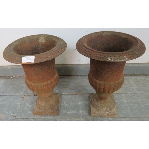 889 - A pair of cast iron fluted garden urns in the Neo-Classical taste, on plinth bases. 
H33 Diameter 23... 