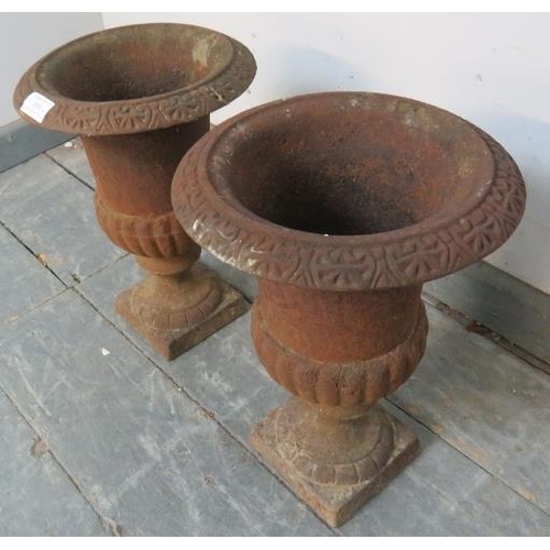 889 - A pair of cast iron fluted garden urns in the Neo-Classical taste, on plinth bases. 
H33 Diameter 23... 