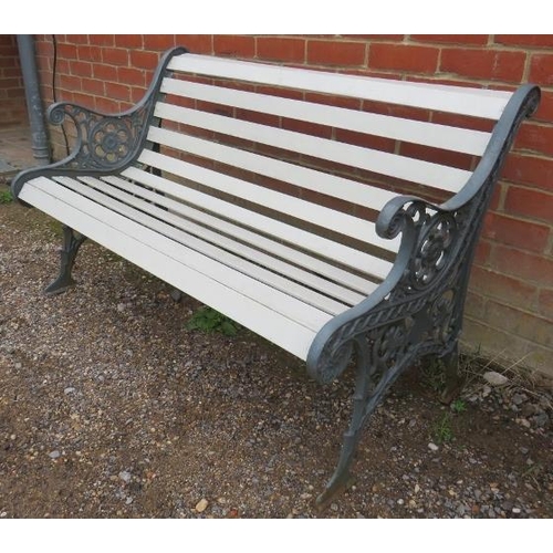 892 - A vintage cast iron two-seater garden bench painted grey and cream, the pierced end supports united ... 