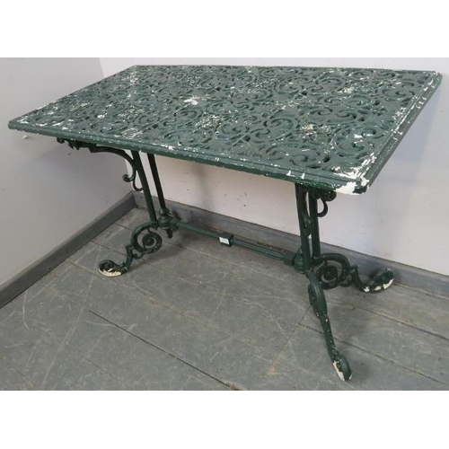 896 - A vintage cast aluminium garden table with an ornate base featuring lion’s heads, on scrolled suppor... 