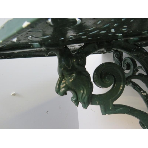 896 - A vintage cast aluminium garden table with an ornate base featuring lion’s heads, on scrolled suppor... 