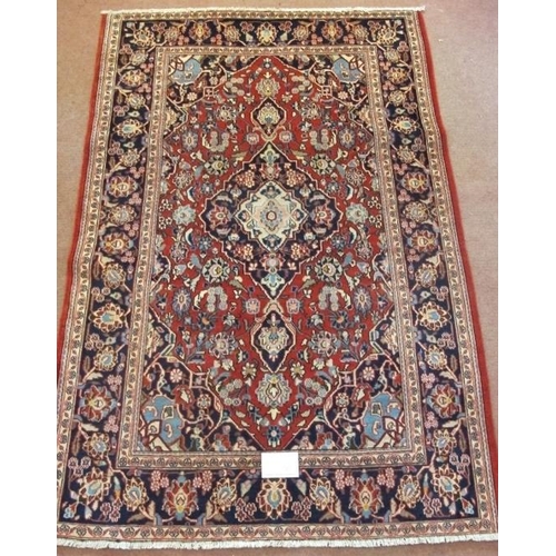 907 - Central Persian Kashan rug floral pattern on red ground, in very clean condition. 195cm x 132cm.