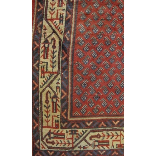 913 - North East Persian Mir runner central small repeat pattern on red ground, with a wide border and in ... 