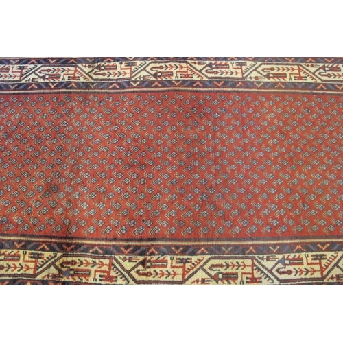 913 - North East Persian Mir runner central small repeat pattern on red ground, with a wide border and in ... 