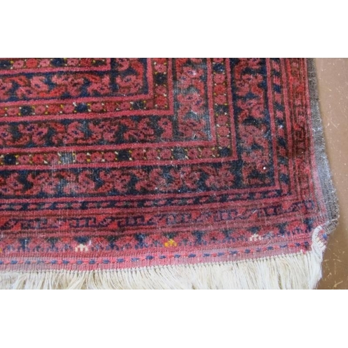 914 - A 20th century Afghan rug with repeat central motifs on deep red ground and wide border, some slight... 