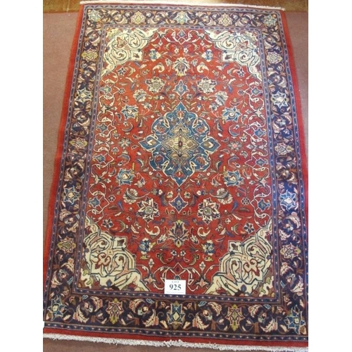 925 - A Persian Sarough rug, central blue motif on red ground and in good condition. 210cm x 142cm.