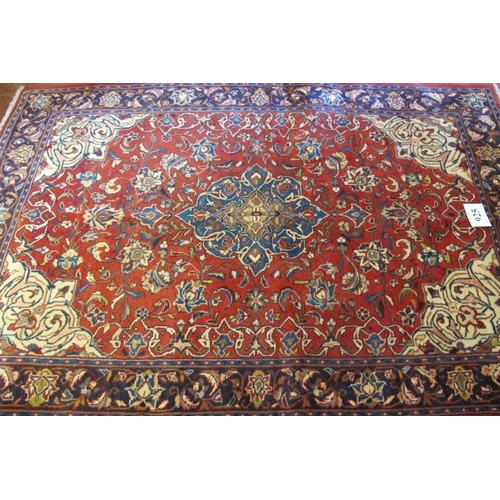 925 - A Persian Sarough rug, central blue motif on red ground and in good condition. 210cm x 142cm.