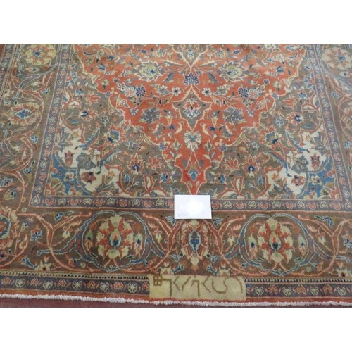 942 - A signed Persian Kashan carpet with central motif on burnt amber field. In good condition. 225cm x 1... 