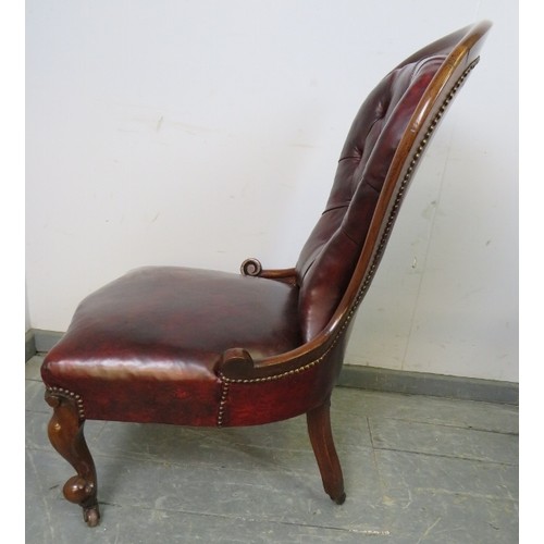 789 - A Victorian mahogany spoonback armchair, upholstered in buttoned burgundy leather with brass studs, ... 