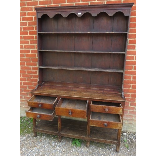 755 - An 18th century oak Welsh dresser, the top with arcaded canopy above three open shelves, the base ho... 