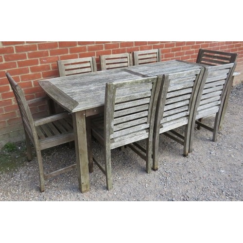 890A - A weathered teak rectangular outdoor table, together with eight (6+2) matching chairs, on square sup... 