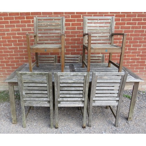 890A - A weathered teak rectangular outdoor table, together with eight (6+2) matching chairs, on square sup... 