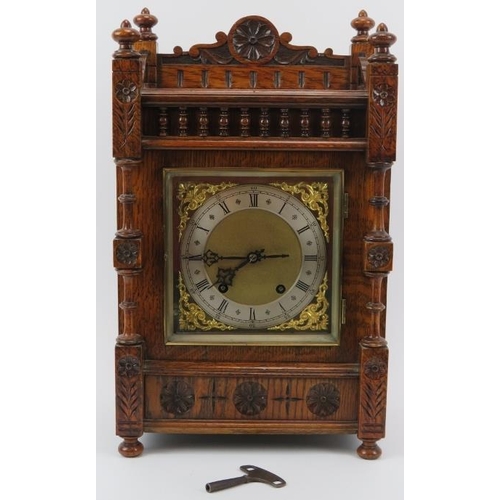 14 - A Black Forest carved oak mantel clock, late 19th/early 20th century. The dial with silvered Roman n... 