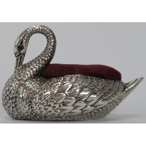 148 - An Edwardian embossed silver swan pin cushion, 20th century. With a red velvet cushion and the blue ... 