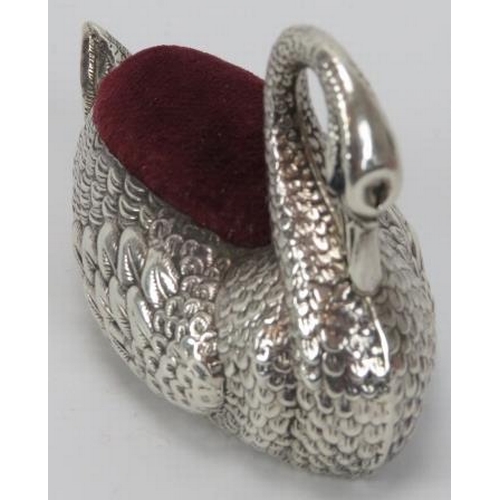 148 - An Edwardian embossed silver swan pin cushion, 20th century. With a red velvet cushion and the blue ... 