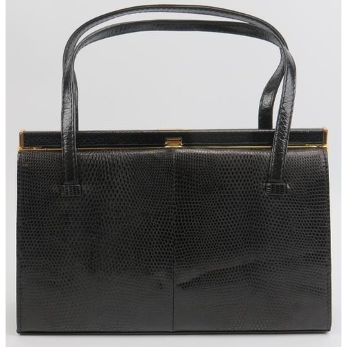 23 - A Mappin & Webb black lizard skin handbag. With gilt metal mounts and clasp, the interior with a zip... 